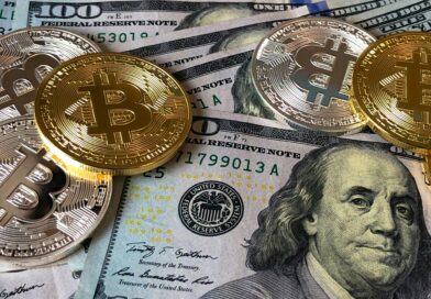 A close-up photo depicting Bitcoin coins on top of US dollar bills, symbolizing finance and cryptocurrency.